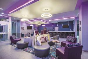 a purple lobby with chairs and a bar at La Quinta by Wyndham Lubbock South in Lubbock