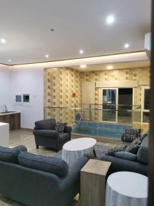a living room with couches and tables and a pool at Private Sand Bond in Al Raka