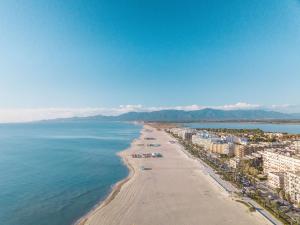 eine Luftansicht auf einen Strand mit Gebäuden und das Meer in der Unterkunft Best Western Plus Hotel Canet-Plage in Canet-en-Roussillon