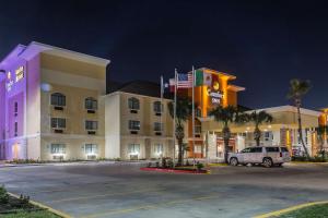 a hotel with a car parked in a parking lot at MainStay Suites Edinburg in Edinburg