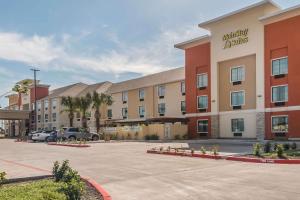 a hotel with a parking lot in front of it at MainStay Suites Edinburg in Edinburg