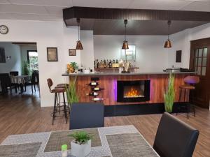 a living room with a fireplace and a bar at Niederdreisbacher Hof in Niederdreisbach