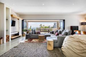 uma sala de estar com um sofá e uma mesa em Solar-Powered Mountain Retreat with Natural Pool em Cidade do Cabo