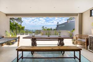 een patio met een houten tafel en een bank bij Solar-Powered Mountain Retreat with Natural Pool in Kaapstad