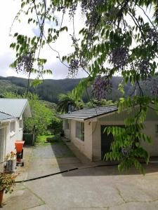 een uitzicht op een huis met een oprit bij Cozy guesthouse at the Rabbithole, Akatarawa Valley in Upper Hutt