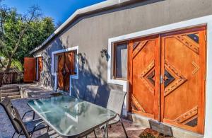 una mesa de cristal y sillas frente a un edificio en Rocky Hollow Lodge, en Pretoria