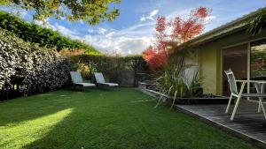 a backyard with two chairs and a lawn at Maison Blanche in Lanton