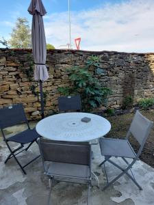 stół, krzesła i parasol na patio w obiekcie Les Dauphins w mieście Saint-Romain-de-Jalionas
