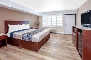 A bed or beds in a room at Travelodge by Wyndham Harbor City