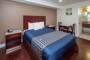 Travelodge by Wyndham Harbor City tesisinde bir odada yatak veya yataklar