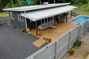 a small house with a deck and a swimming pool at Te Etu Villa 1 in Rarotonga