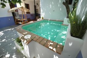 une petite piscine entourée d'une clôture en bois. dans l'établissement Hotel Casa de los Azulejos, à Cordoue