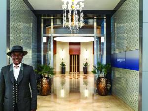 a man in a suit and hat standing in a lobby at Swissôtel Al Ghurair Dubai in Dubai