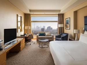 Swissôtel Al Ghurair Dubai في دبي: غرفة فندقية بسرير ونافذة كبيرة