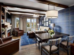 a living room with a table and chairs and a couch at Fairmont Chateau Whistler in Whistler