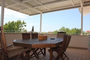 d'une terrasse avec une table et des chaises en bois sur un balcon. dans l'établissement Villa Paradiso del Garda Vista-Verde, à Bardolino