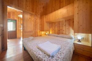 1 dormitorio con 1 cama en una habitación de madera en Casa Bucaneve en Barzio