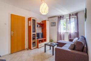 a living room with a couch and a tv at Apartman Merula in Mali Lošinj