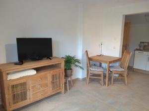 een woonkamer met een tv en een tafel met stoelen bij Ferienwohnung Bauer Katrin und Florian in Prien am Chiemsee