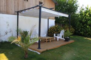 a gazebo with a bench on a wooden deck at Gite La Luciole in Tourtrol