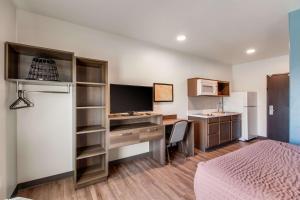 um quarto de hotel com uma secretária e uma cama em WoodSpring Suites Bakersfield Airport em Bakersfield