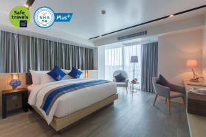 Wintree City Resort في شيانغ ماي: غرفه فندقيه بسرير ومكتب وكراسي