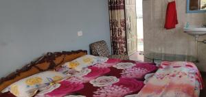 1 dormitorio con 1 cama con sábanas rosas y blancas en Vishnu Rest House, en Varanasi