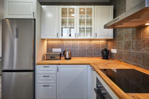 a kitchen with white cabinets and a stainless steel refrigerator at BBarcelona Fira Superior Flats in Barcelona