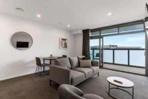 un soggiorno con divano e tavolo di Ramada by Wyndham Newmarket Auckland ad Auckland