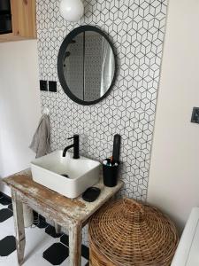 a bathroom with a sink and a mirror at Wiejska chatka in Darłowo