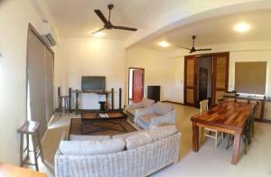 a living room with two couches and a wooden table at Iddamal Apartments in Mount Lavinia