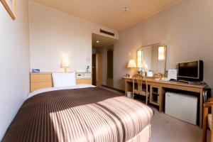 a hotel room with a bed and a desk at Oyama Palace Hotel in Oyama