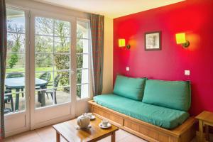 a room with a couch and a window and a table at Residence du Lac - maeva Home in Monflanquin