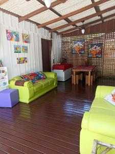 ein Wohnzimmer mit grünen Sofas und einem Tisch in der Unterkunft RECANTO DO SOL "Aluguel de quartos - Hospedagem Simples" in Ilha do Mel