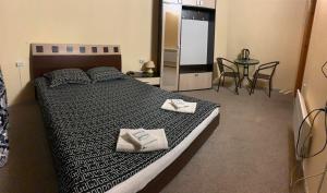 a bedroom with a large bed with two towels on it at Mini-Hotel Sakvoyage in Chernivtsi