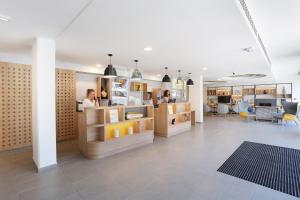 a woman is standing in a room with a store at Appart Hotel Odalys City Toulouse Centre Compans Caffarelli in Toulouse
