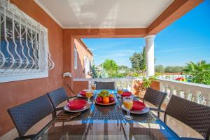 a dining room with a table and chairs on a balcony at Zante Sun II - Getaway Villa! in Kalpaki