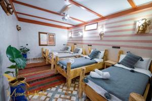 Un grupo de 4 camas en una habitación en Mount Toubkal Lodge en Imlil