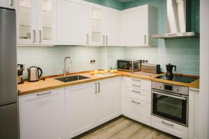a kitchen with white cabinets and a sink at BBarcelona Fira Superior Flats in Barcelona