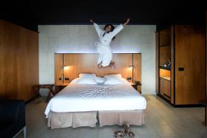 a woman jumping in the air over a bed at Barcelona Princess in Barcelona