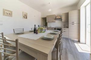 a dining room table with chairs and a kitchen at Villa Salux by HDSalento in Taurisano