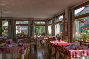 a restaurant with red and white tables and windows at Hotel Le Chamois Logis in Molines-en-Queyras