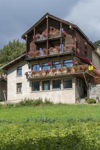 a house with a balcony with flowers on it at Hotel Le Chamois Logis in Molines-en-Queyras