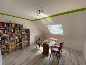 布特亞丁根的住宿－Pension zum Leuchtfeuer，配有桌椅和书架的房间