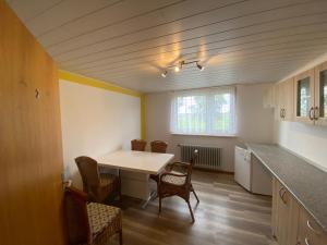 a kitchen with a table and chairs in a room at Pension zum Leuchtfeuer in Butjadingen