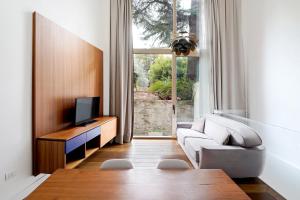 sala de estar con sofá blanco y TV en numa I Vita Apartments, en Florencia