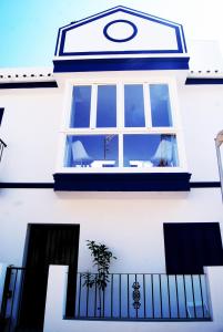 een raam aan de zijkant van een wit huis bij Casa López- Lujosa casa de playa en Málaga in Málaga