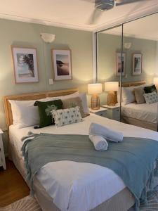 a bedroom with two beds and a mirror at Marina Terraces Port Douglas in Port Douglas