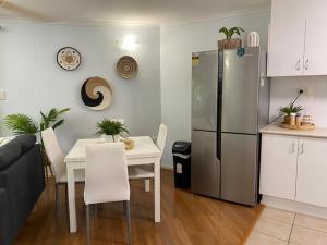 a kitchen with a table and a stainless steel refrigerator at Marina Terraces Port Douglas in Port Douglas
