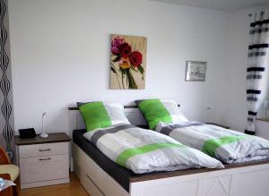 a bedroom with two beds with green and white pillows at Kolks Huus Seglerweg in Neuharlingersiel